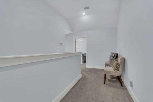 corridor with light carpet and lofted ceiling