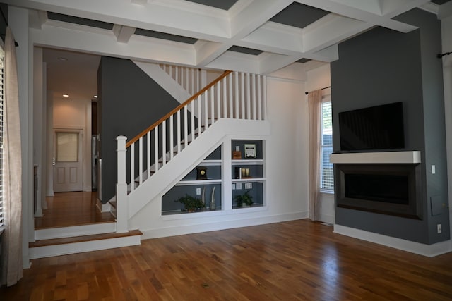 unfurnished living room with hardwood / wood-style floors, crown molding, coffered ceiling, and beamed ceiling