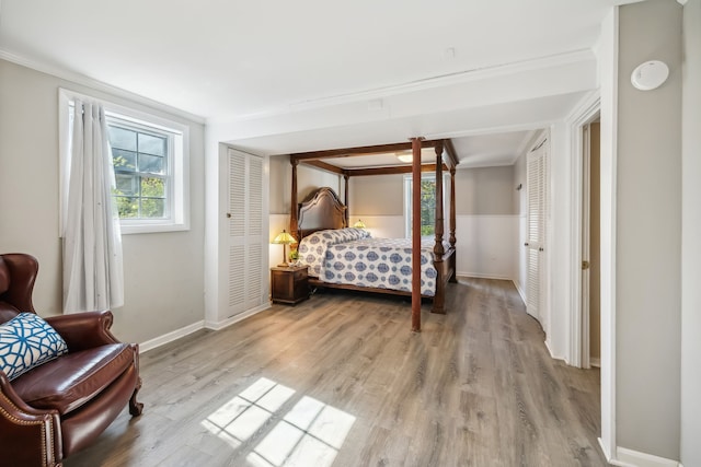 bedroom featuring ornamental molding, a closet, and light hardwood / wood-style flooring