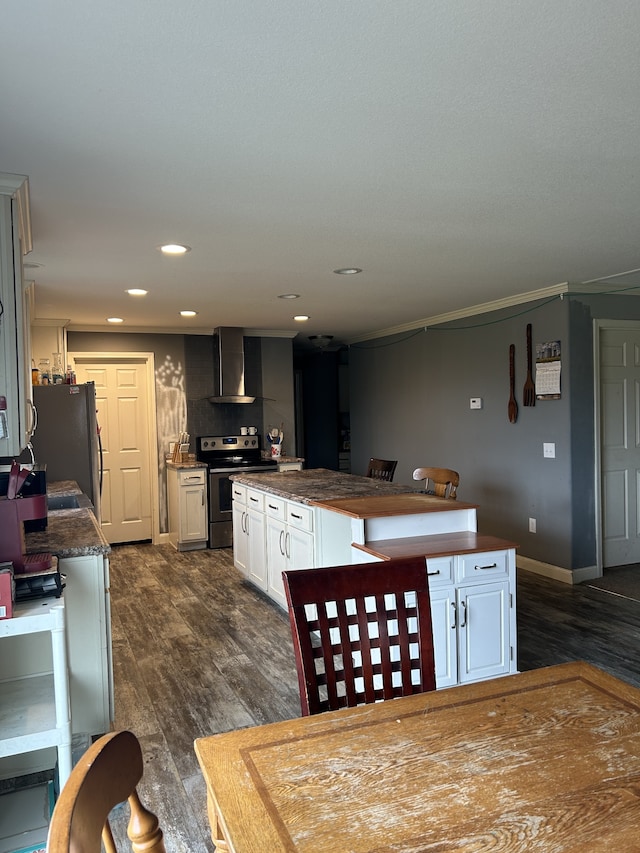 kitchen featuring wall chimney exhaust hood, sink, white cabinetry, appliances with stainless steel finishes, and dark hardwood / wood-style flooring