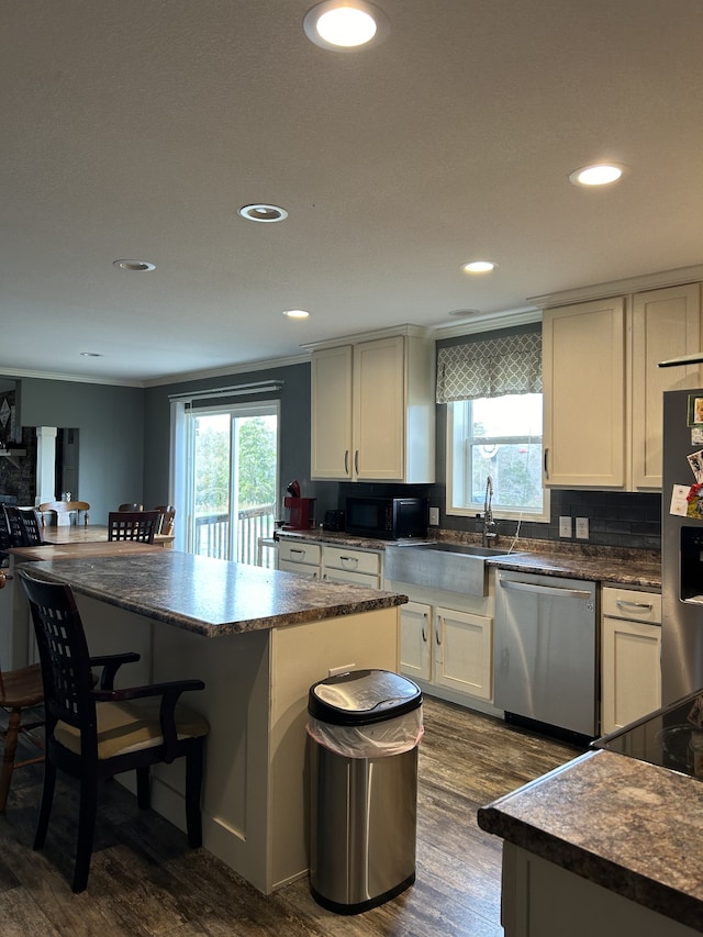 kitchen featuring a center island, stainless steel appliances, dark hardwood / wood-style floors, and plenty of natural light