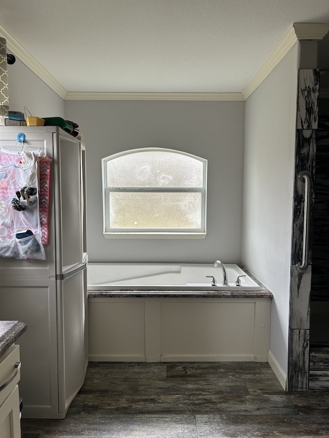 bathroom with vanity, a bathing tub, wood-type flooring, and ornamental molding