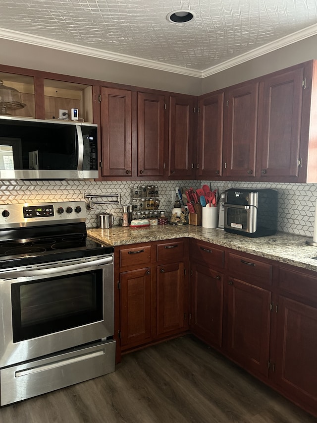 kitchen featuring dark wood-type flooring, crown molding, stainless steel appliances, and backsplash