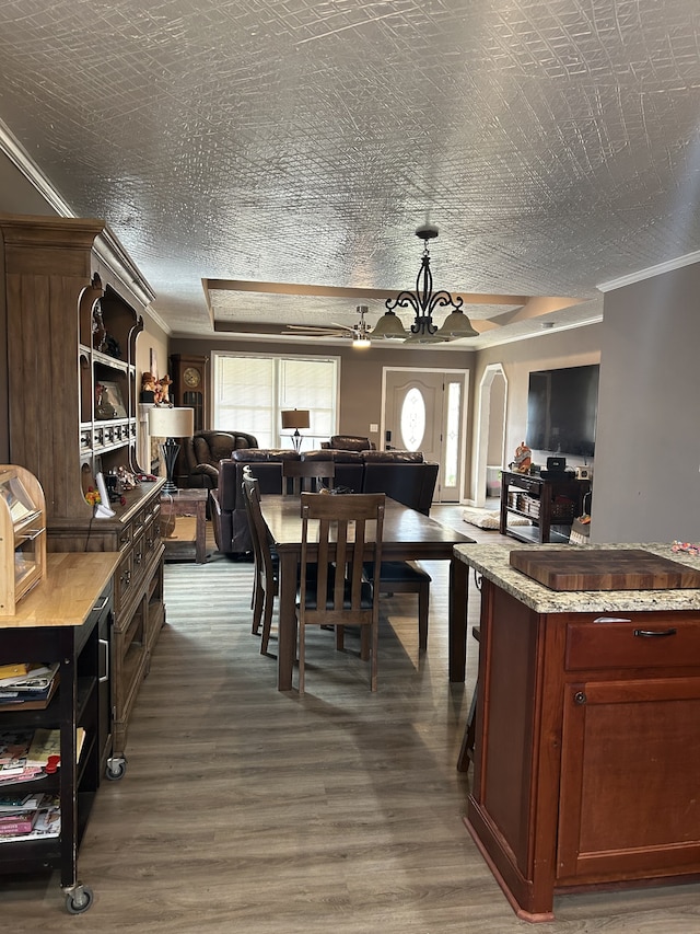 kitchen featuring ornamental molding, a notable chandelier, light stone counters, a textured ceiling, and dark hardwood / wood-style flooring