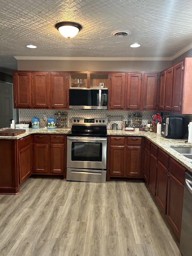 kitchen with stainless steel appliances, sink, crown molding, light wood-type flooring, and tasteful backsplash