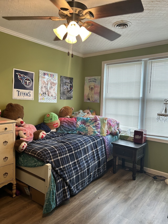 bedroom featuring ceiling fan, crown molding, and hardwood / wood-style floors