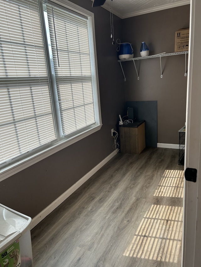 clothes washing area with hardwood / wood-style flooring and ornamental molding