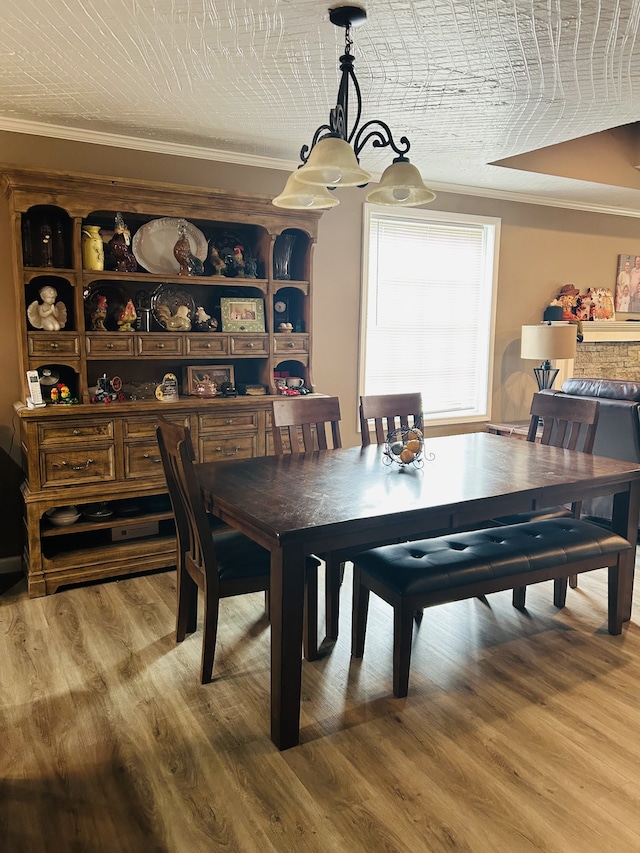 dining room with crown molding, a textured ceiling, hardwood / wood-style flooring, and an inviting chandelier