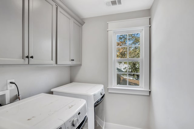 washroom with independent washer and dryer and cabinets