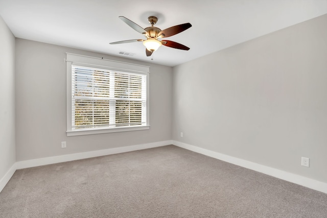 carpeted spare room featuring ceiling fan