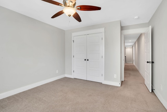 unfurnished bedroom with a closet, ceiling fan, and light colored carpet