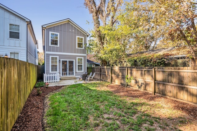 back of house featuring a patio and a yard