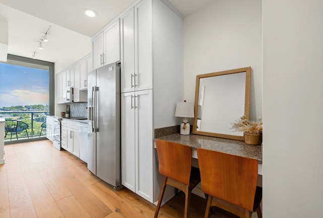 kitchen featuring white cabinetry, stainless steel refrigerator with ice dispenser, dark stone counters, and light hardwood / wood-style floors