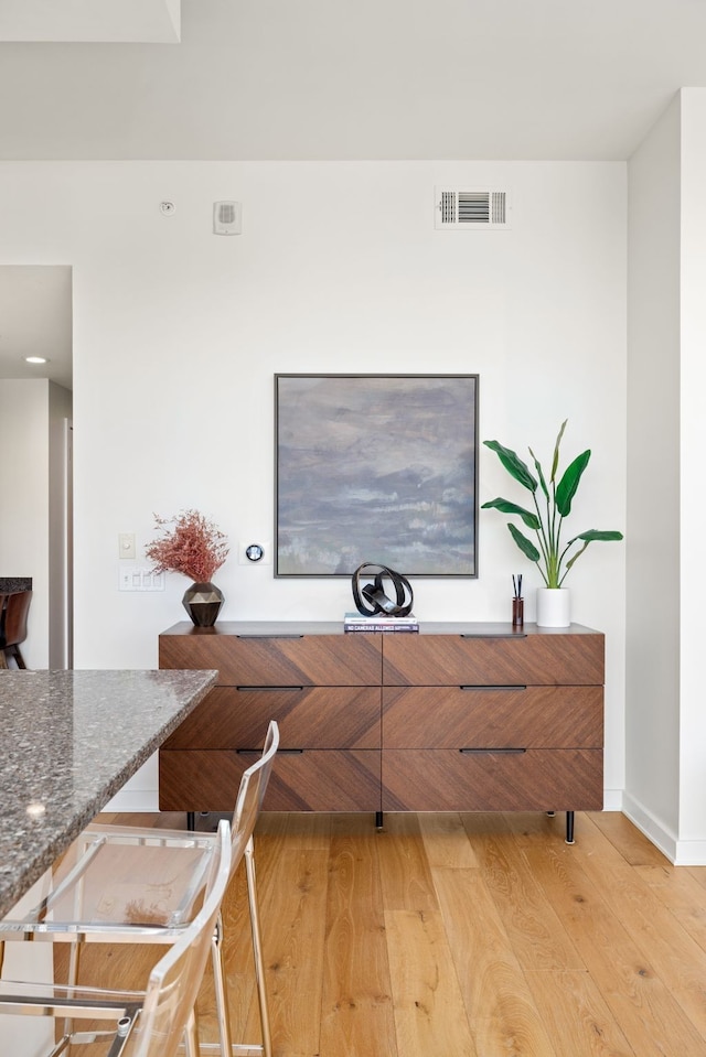 interior space with dark stone counters and hardwood / wood-style floors