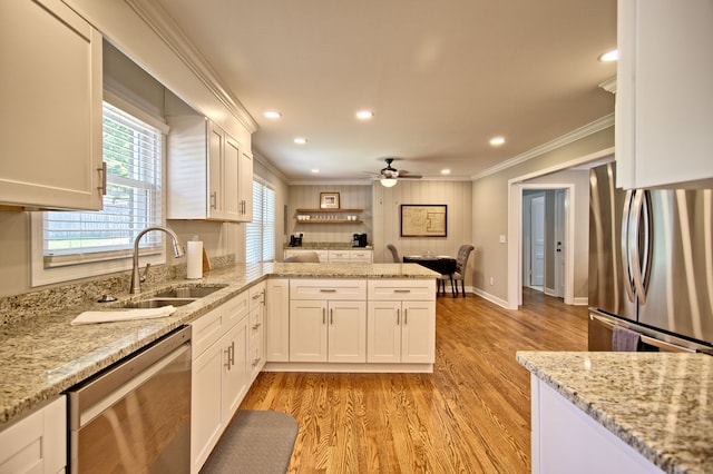 kitchen with white cabinets, stainless steel appliances, sink, and light wood-type flooring