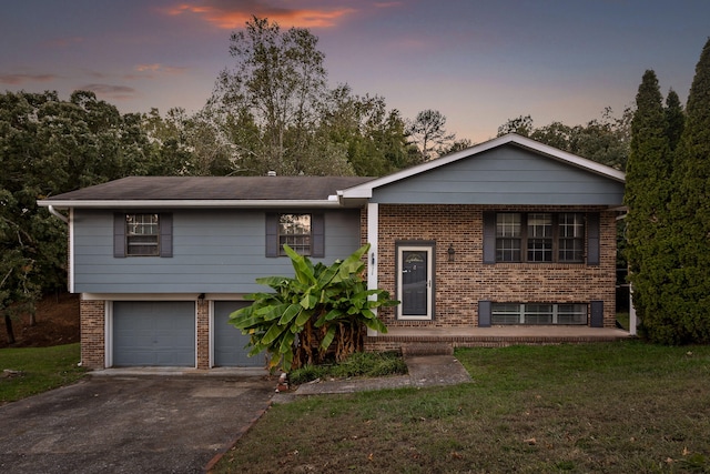 bi-level home featuring a yard and a garage