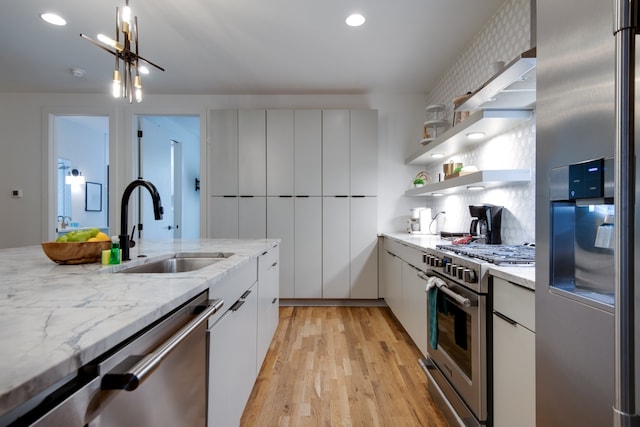 kitchen featuring sink, appliances with stainless steel finishes, light wood-type flooring, and white cabinets