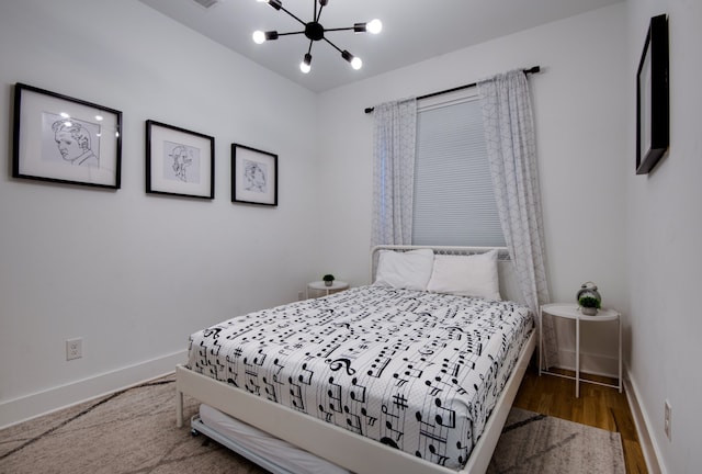 bedroom featuring a chandelier and wood-type flooring