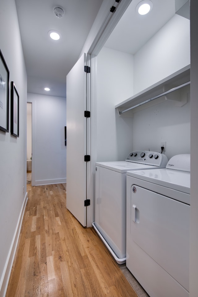 laundry area featuring washer and clothes dryer and light hardwood / wood-style floors