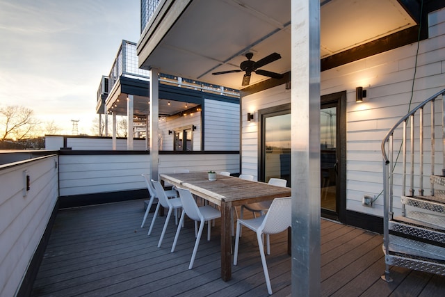 deck at dusk featuring ceiling fan