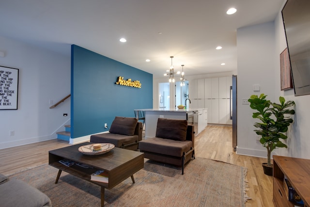 living room featuring light hardwood / wood-style floors and a chandelier