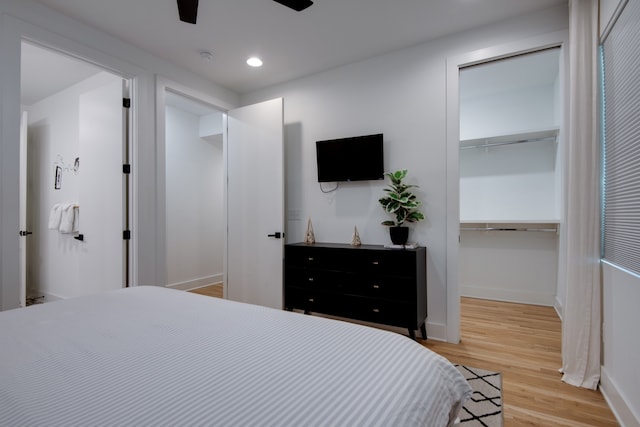 bedroom with a closet, a spacious closet, and wood-type flooring