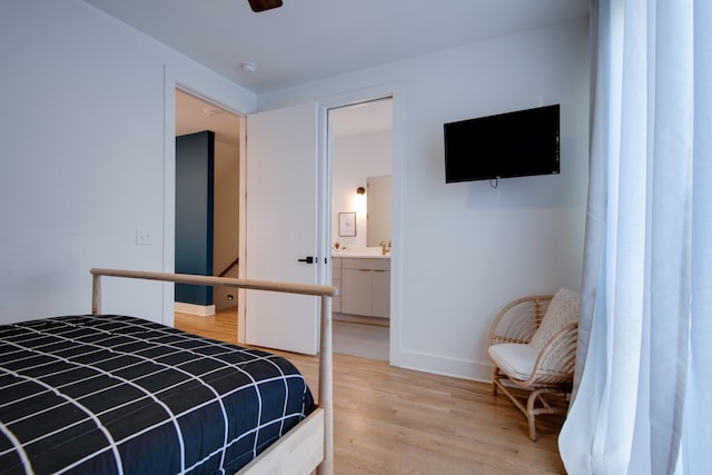 bedroom with hardwood / wood-style flooring, connected bathroom, and ceiling fan