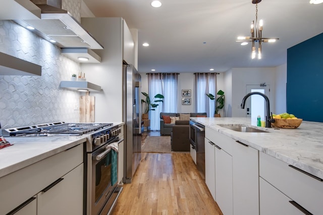 2809 Delaware Ave Unit 202, Nashville, TN 37209 - kitchen featuring stainless steel appliances, range hood, open shelves, backsplash, and light wood-style flooring