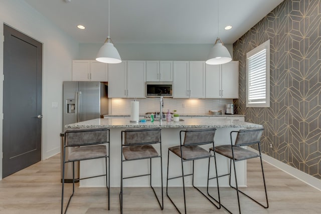 1112 Harmony Way, Nashville, TN 37207 - kitchen with appliances with stainless steel finishes, wallpapered walls, white cabinets, light stone counters, and decorative light fixtures