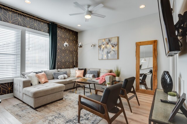 living room with light wood-type flooring and ceiling fan