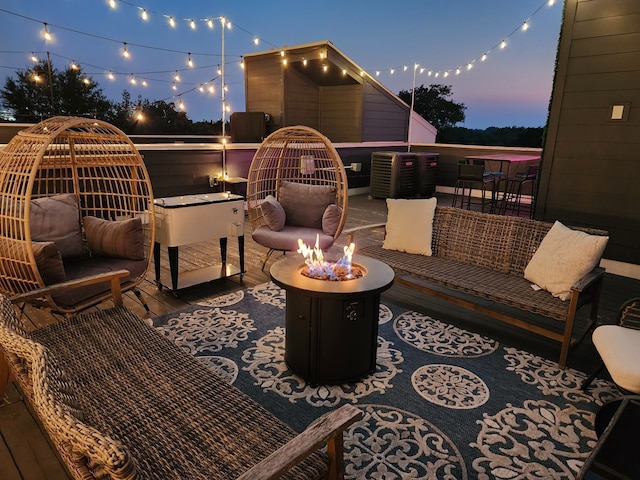 deck at dusk with an outdoor living space with a fire pit