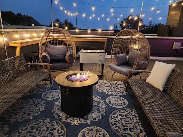 patio at night with an outdoor living space with a fire pit