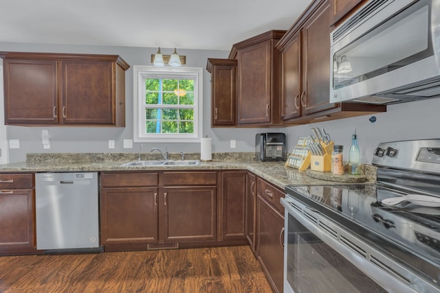 kitchen featuring sink, appliances with stainless steel finishes, light stone counters, and dark hardwood / wood-style flooring