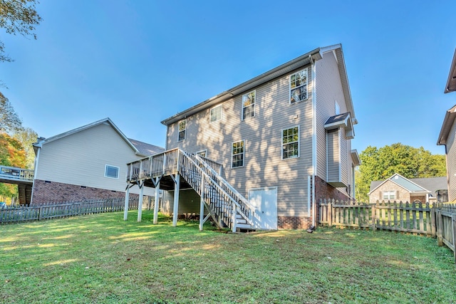 rear view of property with a wooden deck and a yard