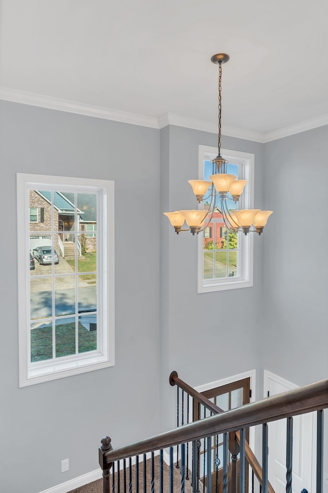 stairway with crown molding, a wealth of natural light, and a chandelier