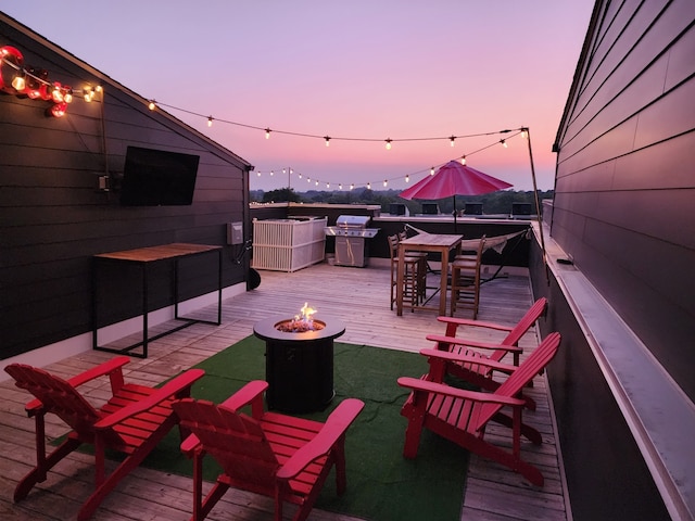 view of patio / terrace with a deck, grilling area, and a fire pit