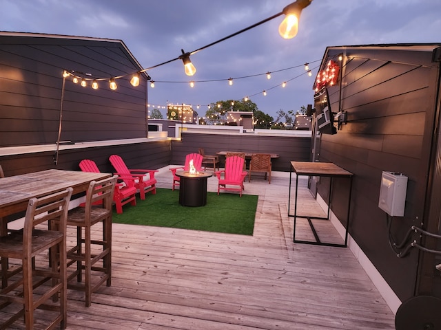 deck at dusk featuring a fire pit