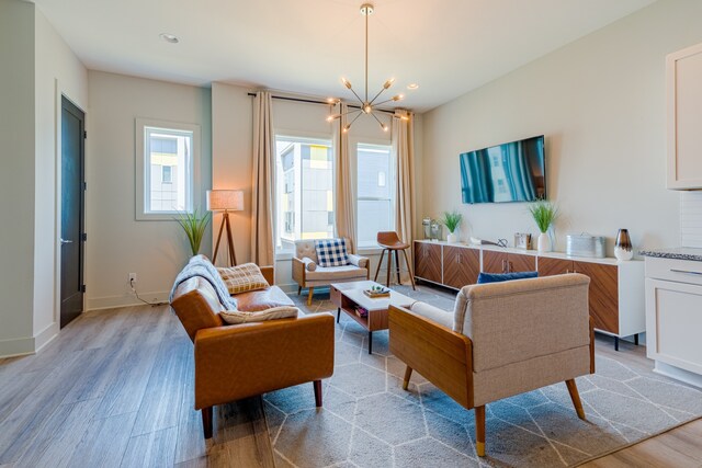 living room with light hardwood / wood-style flooring and a notable chandelier