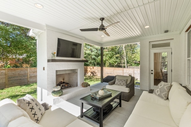 sunroom / solarium featuring an outdoor brick fireplace and ceiling fan