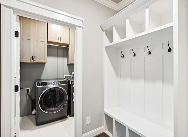 washroom featuring cabinets, washing machine and dryer, and crown molding