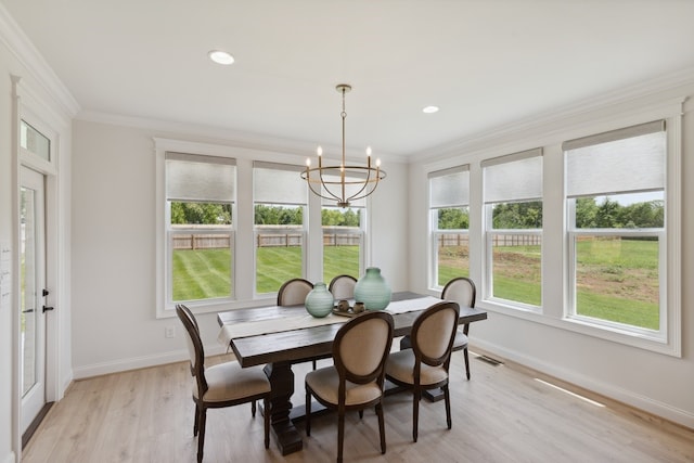 dining room featuring ornamental molding, a notable chandelier, and light hardwood / wood-style flooring