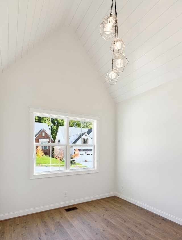 empty room featuring high vaulted ceiling and wood-type flooring