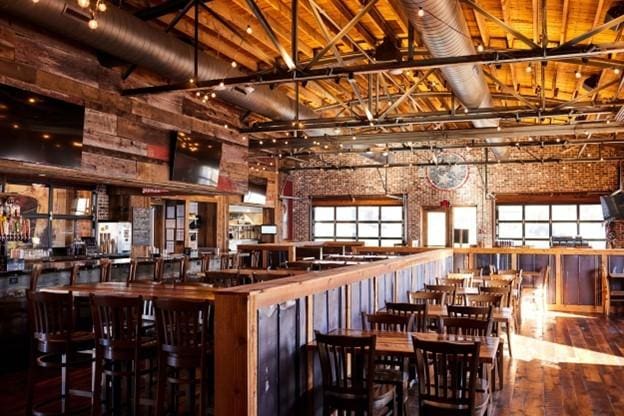 bar featuring high vaulted ceiling, a wealth of natural light, wood walls, and wood-type flooring