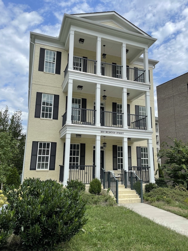 view of front of home featuring a porch, a front yard, and a balcony