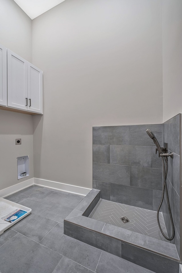 interior space featuring tile patterned floors, electric dryer hookup, and cabinets