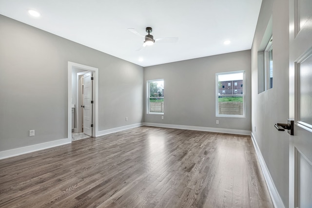 empty room with hardwood / wood-style floors and ceiling fan