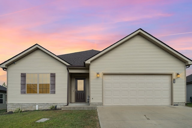 ranch-style house featuring a garage and a lawn