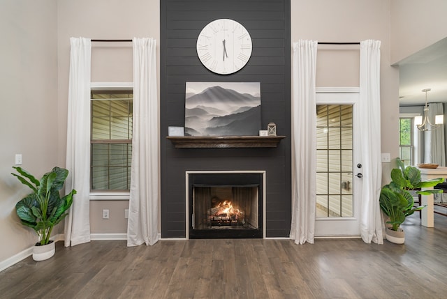 room details featuring a large fireplace and wood-type flooring