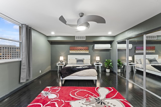 bedroom with a closet, dark hardwood / wood-style floors, a wall unit AC, and ceiling fan