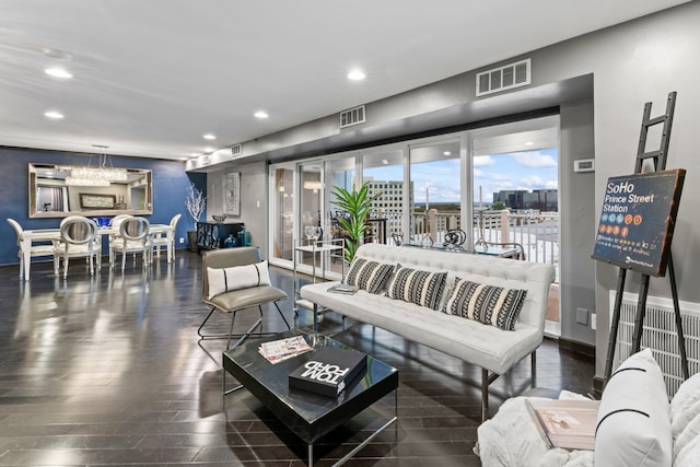 living room featuring a notable chandelier and dark hardwood / wood-style flooring